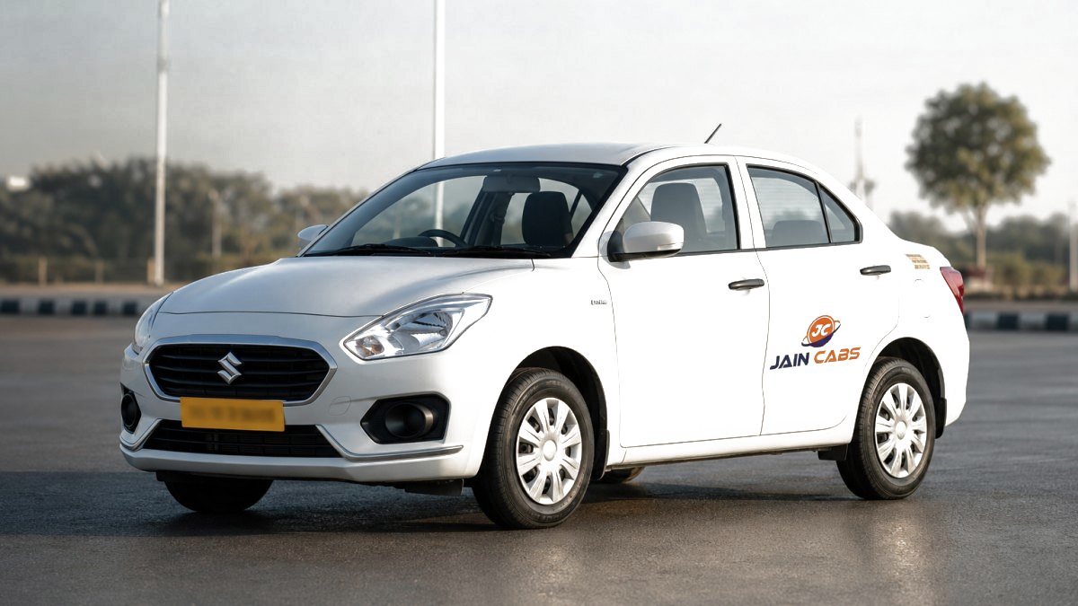 A white Sedan A/C operated by Jain Cabs, 4+1 seats, photographed on a clear road with its yellow commercial number plate visible.
